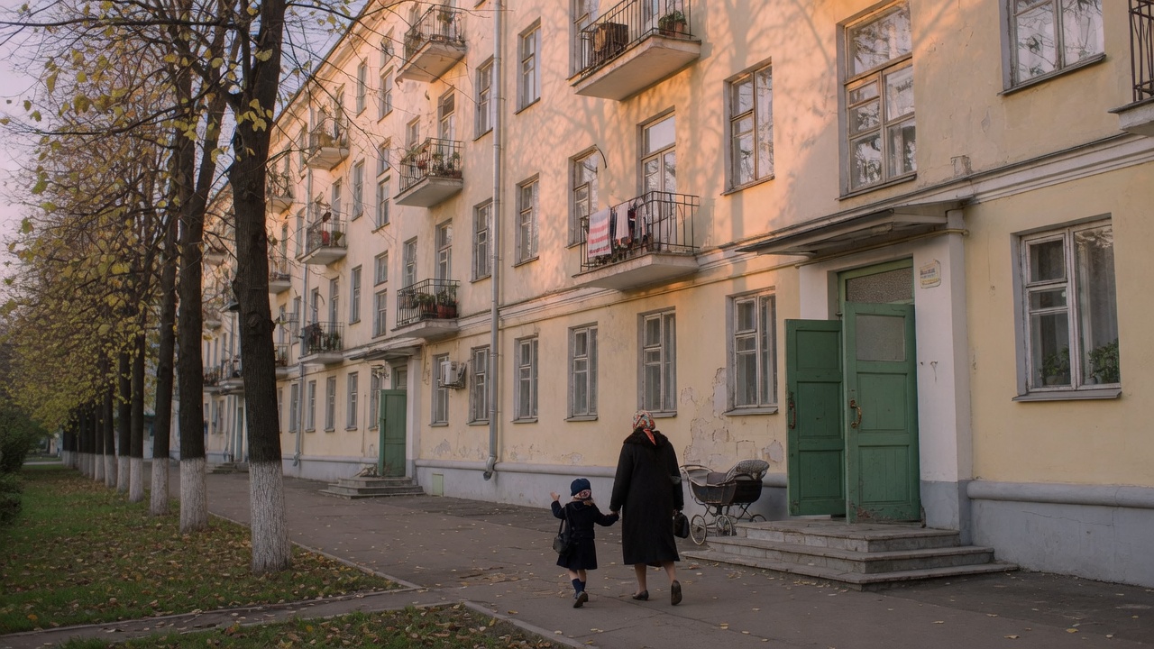 Дом на тихой улице: вход с зелёной дверью, деревья, вечерний свет